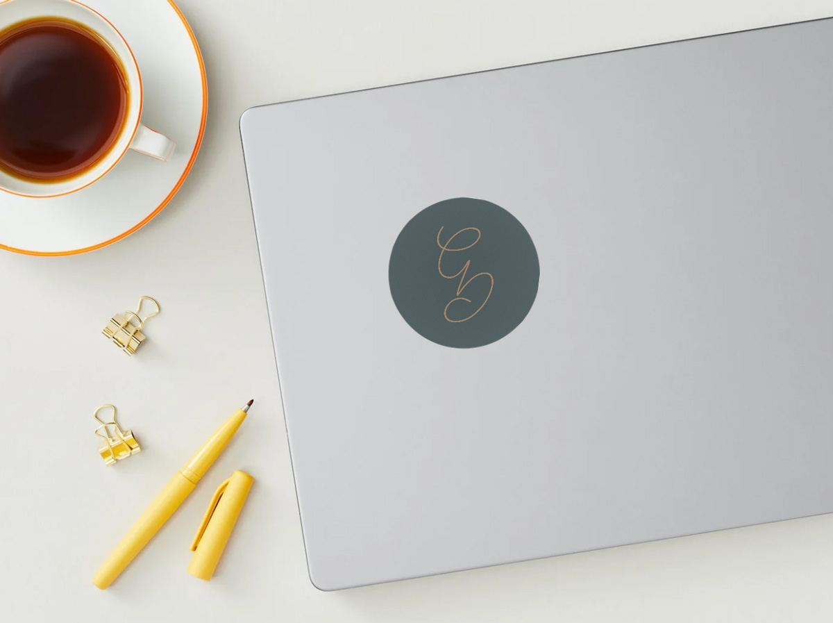 Runder Sticker mit Initialen-Logo 'GD' von Greativ Design auf Laptop – minimalistisches Branding mit Fokus auf Wiedererkennung und Farbharmonie.