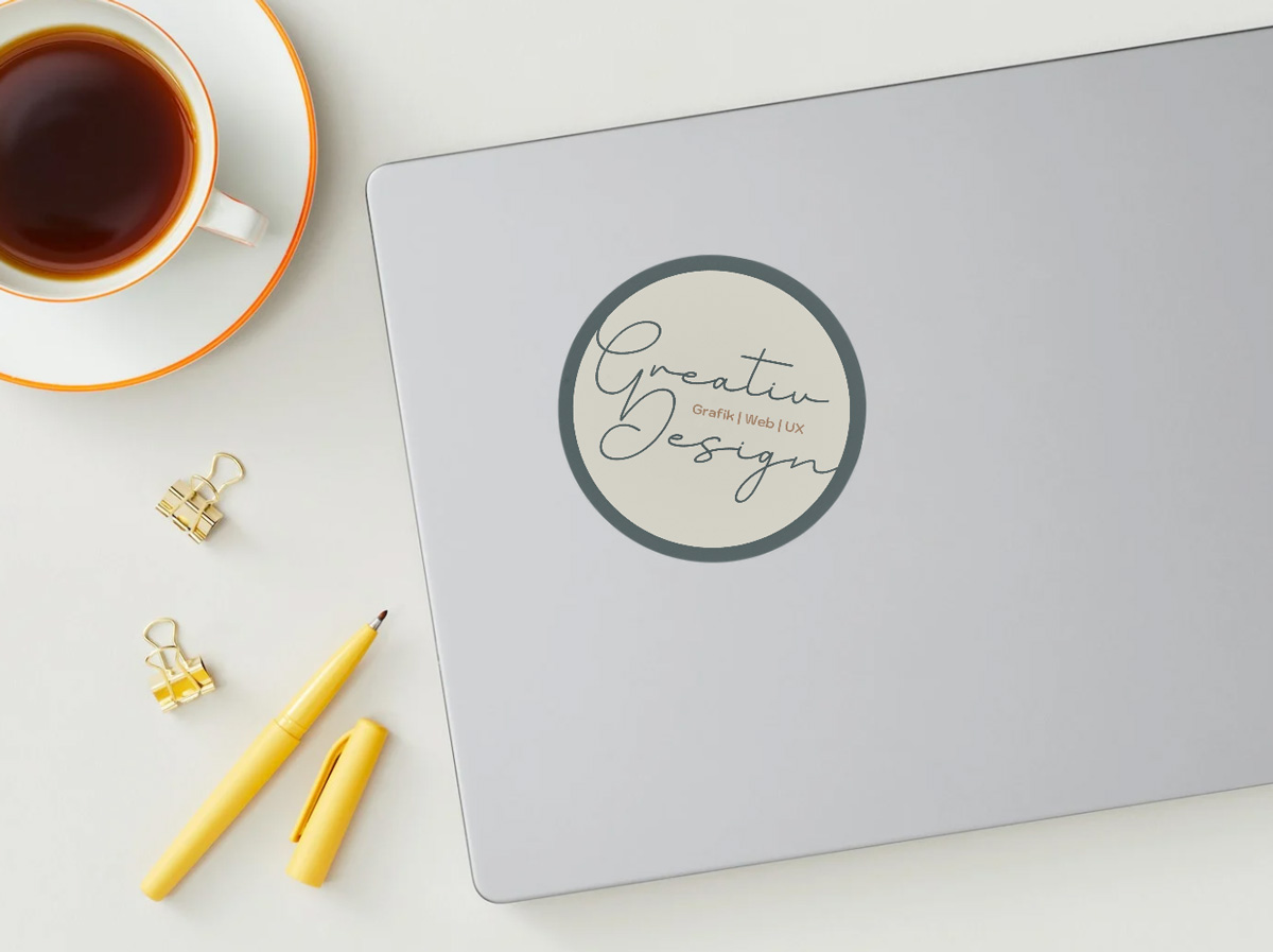 Sticker mit Schriftlogo 'Greativ Design – Grafik | Web | UX' auf Laptop – plakative Markenbotschaft im mobilen Einsatz.